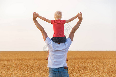 儿子坐在父亲的肩膀上举起手来童年快图片