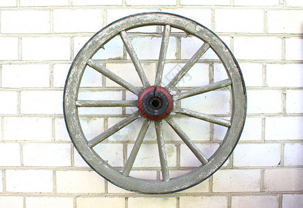 旧木轮挂在砖墙上图片