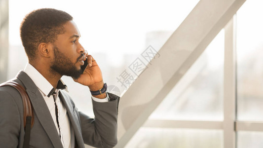 忙碌的非洲商人在机场门外讲电话制作商务旅行图片