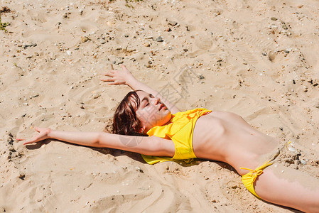 年轻女子在夏天躺在沙滩上那个女孩躺在沙滩上海上的少年假期图片
