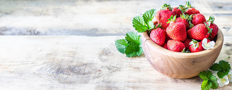 木制背景上的草莓碗图片