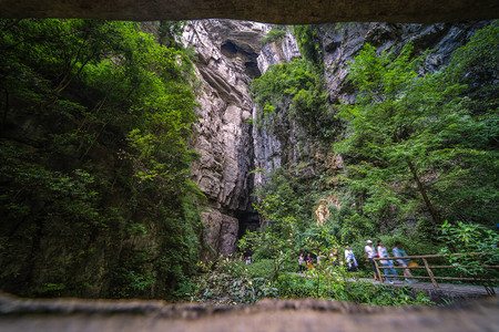 游客在武隆公园巨大的垂直岩壁景观中行图片
