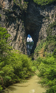 重庆武隆县龙水峡裂隙公园巨大垂直岩壁景观中的泥水流图片