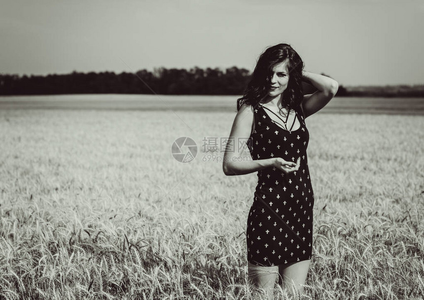 在金色的田野上放松大自然中的年轻女子在夏日阳光下的草地上休息肖像漂亮的女孩图片