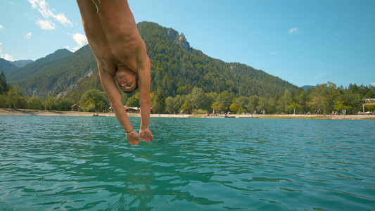 身材健壮的白人男子首先潜入风景如画的斯洛文尼亚山脉中清新的翡翠湖图片
