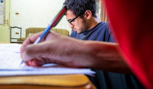 两个男孩坐在一起学习和写作业图片
