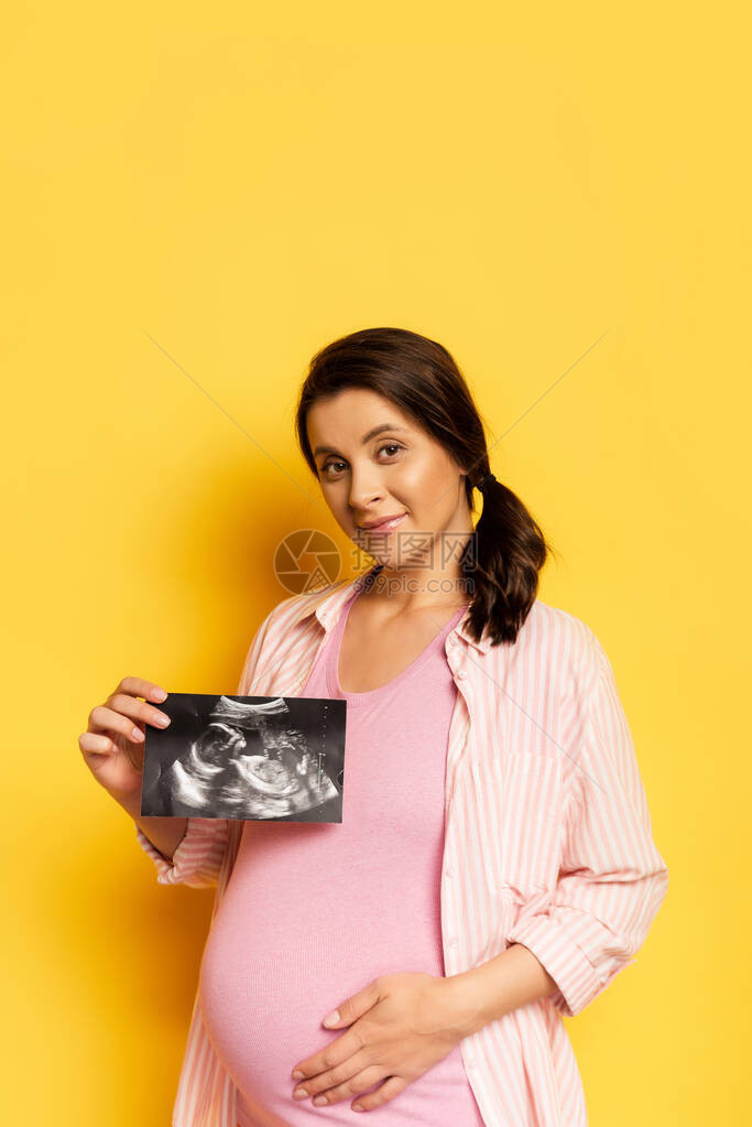 孕妇在用黄色触摸腹部时进图片