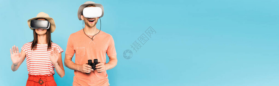 在虚拟现实头盔中兴奋的男子带着双筒望远镜靠近被隔离在蓝色图片