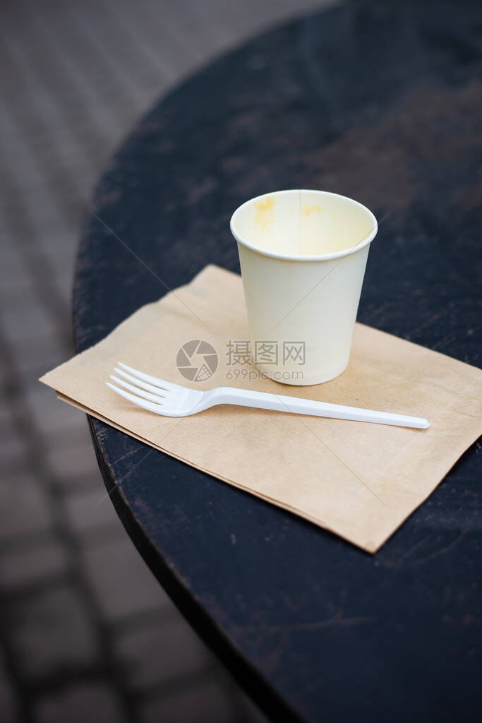 一个装着咖啡的塑料杯站在街上图片