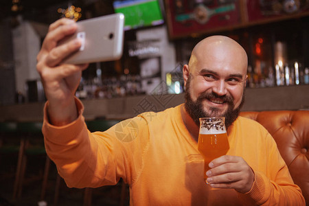 胡子人拿起自拍手里拿着一杯啤酒在酒图片