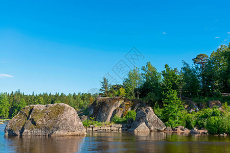 巨石位于岸边的湖水中图片
