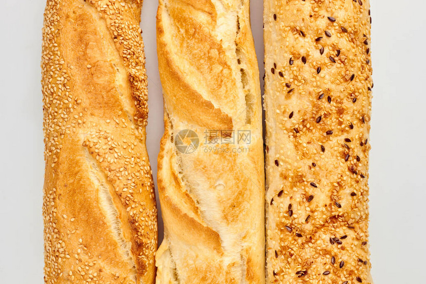 上贴着芝麻和薯片种子的面包长面包饼和地壳美图片