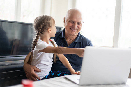 祖父和孙女一起使用笔记本电脑图片