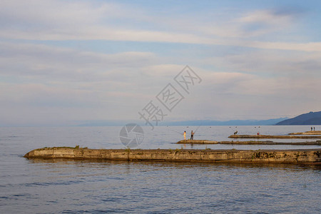 Baikal湖在防波堤上渔民用渔棍钓图片