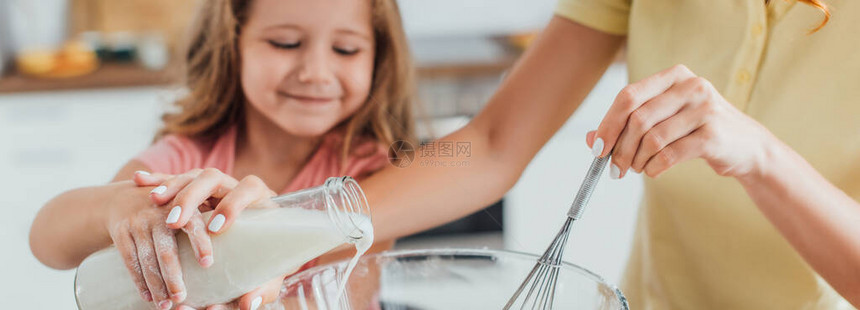 与女儿一起将牛奶倒入玻璃碗中图片