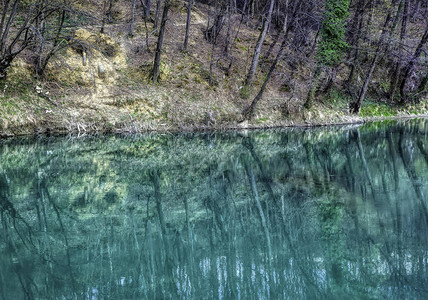 山河在森林周围经过的平静的绿化水图片