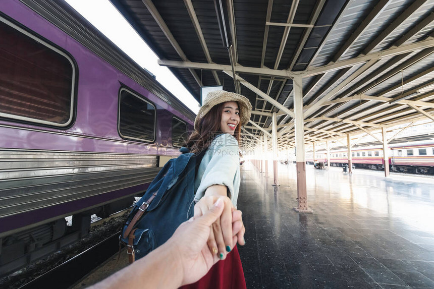 带着男朋友的年轻亚洲女在火车站跟着她微笑图片