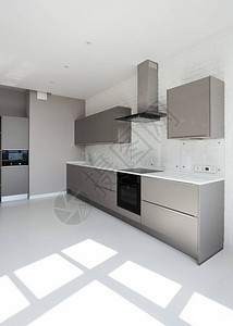 现代住宅的垂直视图与现代室内设计在白色厨房间橱柜家具新水槽水龙头电烤箱炉灶和微波炉附近的背景图片