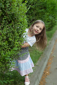 小女孩从公园一棵树后面看图片