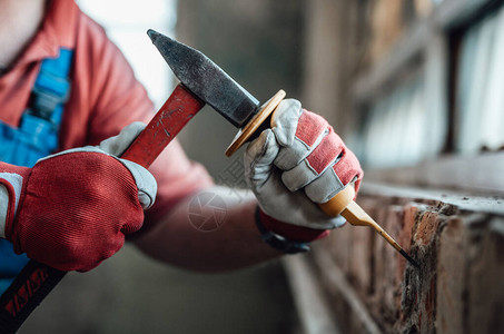 在建筑工地用锤子和砍刀工作时手图片