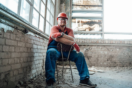 工人坐在建筑工地的旧椅子上时图片