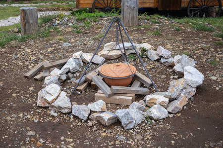 一个古老的原地烹饪锅挂在没有的营火上方的钩子上图片