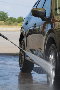 用高压喷水器冲洗汽车前轮图片