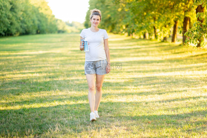 一个怀孕的女孩在夏天在大自然中运动图片