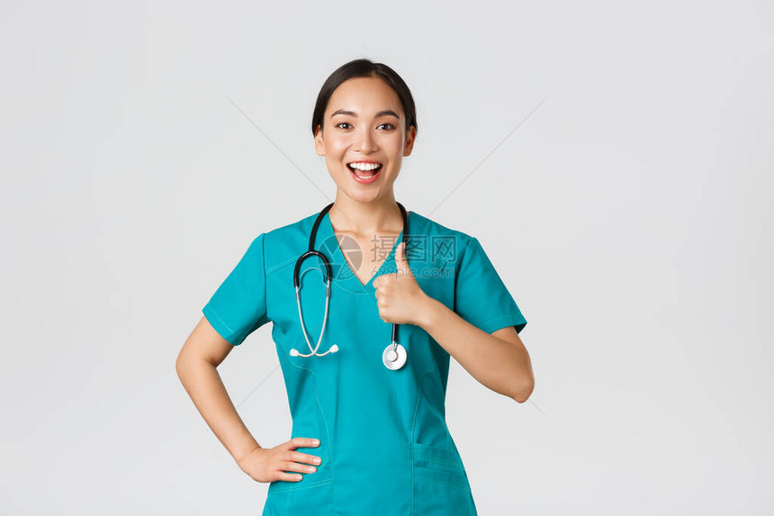 微笑乐观自信的亚洲女护士穿着磨砂膏图片