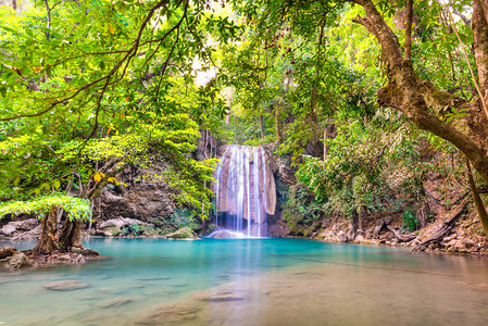 美丽的瀑布和翡翠湖在绿色热带丛林森中泰国北碧府四面佛公图片