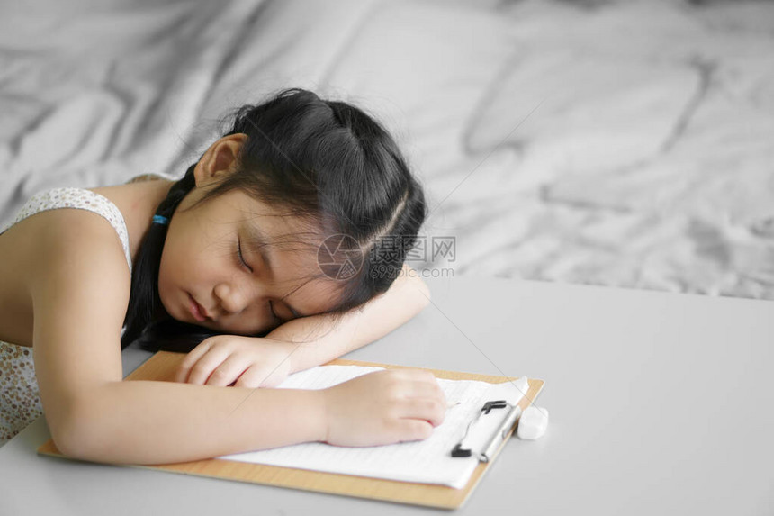 亚洲儿童学生或小女孩写作或绘画和做家庭作业或在家和培训写在纸上但睡着或睡在桌子上休息图片