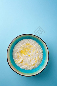 蓝色背景的碗里有黄油的米粥部分图片
