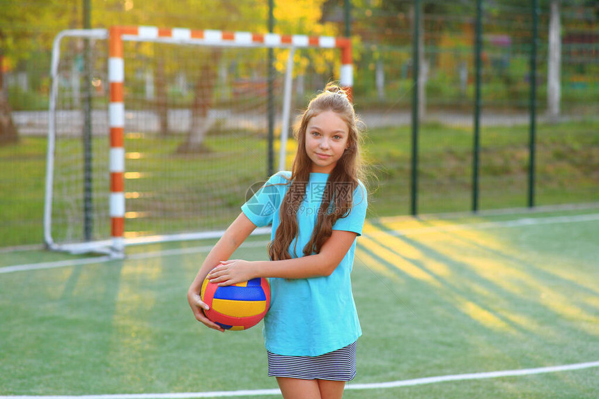 足球场上手里拿着球的女孩放学后的排球训练学校锻炼健图片