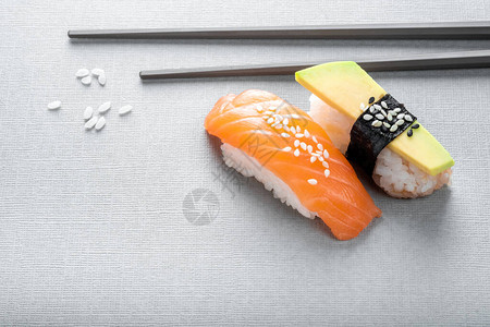 Nigiri寿司和鲑鱼以及灰色背景的鳄梨还背景图片