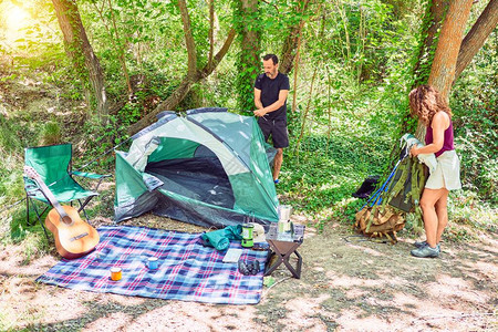 中年夫妇徒步者搭帐篷在森林露图片