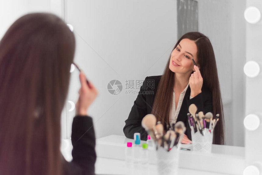 坐在明亮的房间办公室的化妆桌旁图片