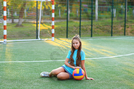 足球场上手里拿着球的女孩放学后的排球训练学校锻炼健图片