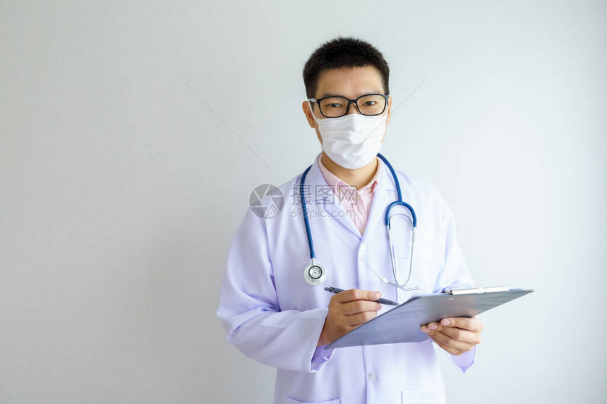 在办公室医院工作的亚洲男医生戴着面罩保护Covid19医疗保图片