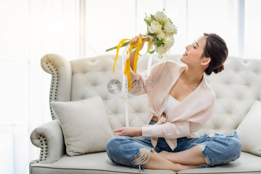 手里拿着男友在客厅送来的惊喜白玫瑰花束图片