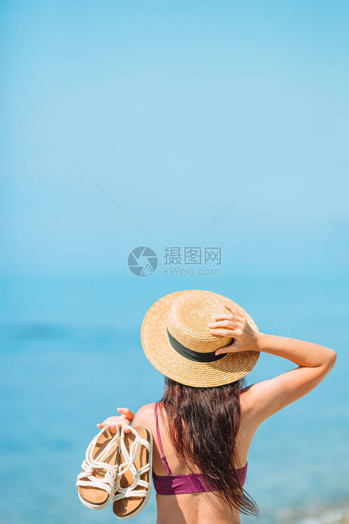 在白沙滩上戴着鞋子戴帽子的图片