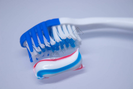 牙膏旁边的白色背景上的牙刷图片