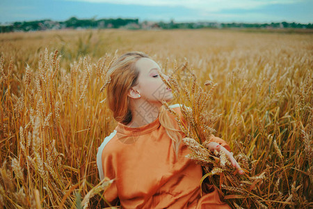一个优雅的模特躺在麦田上享受大自然图片