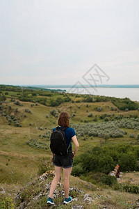 背着包站在悬崖边缘仰望天空和美丽自然的年轻女发现荒野的地方国内旅游业图片