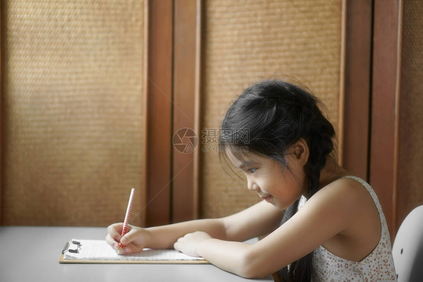 亚洲儿童可爱或小女孩微笑写作或绘画图片