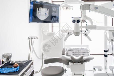 带有椅子灯具显示器上的牙科扫描和口腔学工具的牙图片