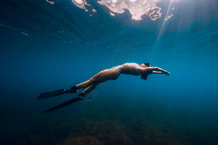 女自由潜水者在蓝海中放松鳍水下图片