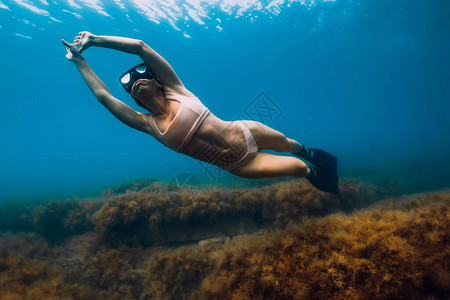 运动的女自由潜水者有鳍滑翔图片