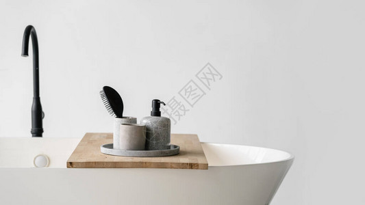 在靠近黑色水龙头的白色现代浴室的木架上图片