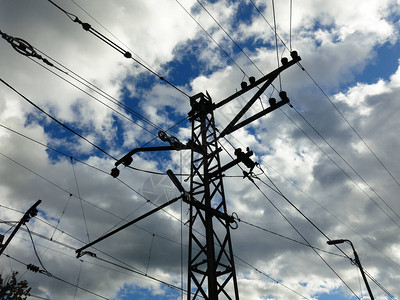 在天空背景的铁路上方的电线的金属支图片