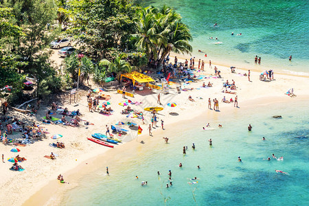 以白色沙滩和蓝色透明水及珊瑚礁为最顶端的孤立热带小岛景色背景图片